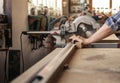 Craftsman cutting wood with a mitre saw in his workshop