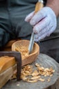 Craftsman demonstrates the process of making wooden spoons handmade using tools. National crafts concept. Royalty Free Stock Photo