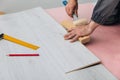 A Craftsman Demonstrating Precision Flooring Installation Techniques with Tools, Measuring Devices, and Engineered Wood Panels in Royalty Free Stock Photo