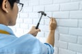 Craftsman doing renovation work at home improvement with using hammer to driving nail on brick wall and interior design concept Royalty Free Stock Photo