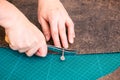 Craftsman draws pattern on the carved leather