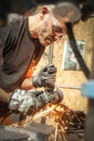 Craftsman with electric grinder tool on steel structure in factory Royalty Free Stock Photo