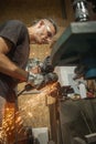 Craftsman with electric grinder tool on steel structure in factory Royalty Free Stock Photo