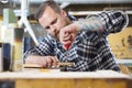 Craftsman files wooden guitar neck in workshop Royalty Free Stock Photo