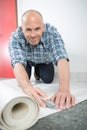 Craftsman fitting carpet on floor Royalty Free Stock Photo