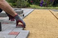 Hands of a worker in gloves laying concrete blocks with a rubber hammer Royalty Free Stock Photo