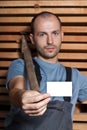 Craftsman with a hammer holding a business card