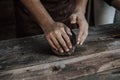 Craftsman hands close up, kneads and moistens the clay.