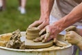 Craftsman hands form a clay bowl on a traditional pottery wheel, ethnography study in making of traditional eco-friendly kitchen