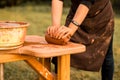 Craftsman hands kneads clay for making pottery bowl. Man working on potter wheel Royalty Free Stock Photo