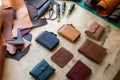 Craftsman hands laying out leatherwork on wooden table at leather workshop. Handwork accessories