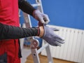 Craftsman holding a saw ready to perform home renovation. Worker in work clothes on a construction site on an aluminum folding Royalty Free Stock Photo