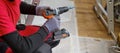 Craftsman holding a screwdriver drill ready to perform home renovation. Worker in work clothes on a construction site on an Royalty Free Stock Photo