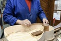 Luthier fitting interior lining blocks into handcrafted flamenco guitar body Royalty Free Stock Photo