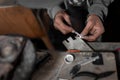 A craftsman jeweler is using a file tool to create a metal cilinder for a bracelet Royalty Free Stock Photo