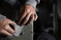 A craftsman jeweler is using a sandpaper to tile a metal cilinder for a bracelet Royalty Free Stock Photo