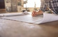 Craftsman leaning over a bench reading furniture design blueprints Royalty Free Stock Photo