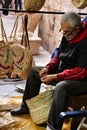 Craftsman making wicker bags at a market stall