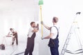 Craftsman painting white wall green while finishing interior Royalty Free Stock Photo