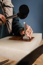 Craftsman is punching genuine leather using line punch and hammer for creation natural leather products. Tools of Royalty Free Stock Photo