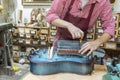 Craftsman repairs Hurdy-gurdy wheel vielle in workshop.