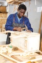 Craftsman restoring old chest of drawers Royalty Free Stock Photo