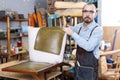 Craftsman reupholstering chair in workshop