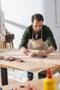 Craftsman sanding surface of wooden board