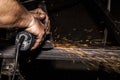 Craftsman sawing metal with disk grinder in workshop. Grinding metal with sparks flying Royalty Free Stock Photo