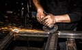 Craftsman sawing metal with disk grinder in workshop. Grinding metal with sparks flying Royalty Free Stock Photo