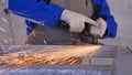 Craftsman sawing metal with disk grinder in workshop. Grinding metal with sparks flying. Electric wheel grinding on Royalty Free Stock Photo