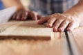 Craftsman sawing planks of wood in his carpentry workshop