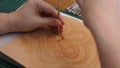 Craftsman stamps the drawing of flower on leather with Beveler Stamping tool