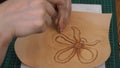 Craftsman stamps the relief of flower on leather with Beveler Stamping tool