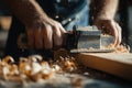 A craftsman using a hand plane to shape wood, creating shavings in a workshop