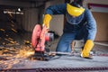 Craftsman Welding is Cutting Steel Work, Welder Man in Safety Protective Equipment Doing Metalwork in Construction Site. Royalty Free Stock Photo