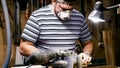 Craftsman working with grinding machine at wood workshop.