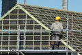 Craftsman working on a roof from a scaffold. Royalty Free Stock Photo