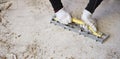 Craftsman in workwear who, using the rabot, removes excess glue left on the floor after removing the wooden parquet glued to the