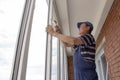 Craftsmen workers install window in house rattle with a special rubber hammer Royalty Free Stock Photo