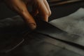 craftsperson carefully skiving leather to thin the edge