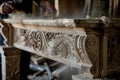 craftsperson dusting a newly carved wooden mantelpiece