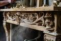 craftsperson dusting a newly carved wooden mantelpiece