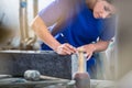 Craftswoman applying template for engraving on headstone