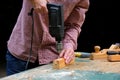 Craftswoman drilling a hole with an electric drill machine in wooden plank, closeup view. Concept of joiner`s shop and woodworkin Royalty Free Stock Photo