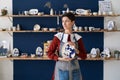 Craftswoman posing with handmade plate after decorating pottery with hand drawn ornament Royalty Free Stock Photo