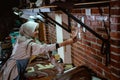 Craftswoman in veil makes sticky notes on wall while working