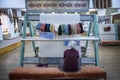 a craftswoman woman on her back weaves a wool carpet with her hands on a loom, Turkish handmade carpets, Cappadocia, Turkey