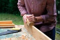 Craftswoman working with carpentry plane outdoors. Close-up view. Woodworking concept