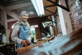 Craftwoman smiling while cutting leather fabric in studio